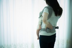 Babywearing mother with backpain